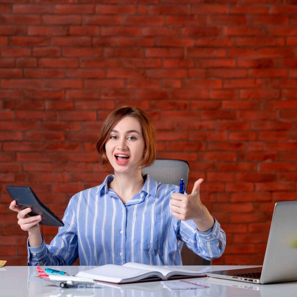 front-view-travel-agent-sitting-her-working-place-with-laptop-working-with-calculator-map-agency-service-manager-assistant-ticket-world-global (1)